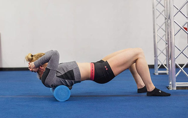 ورزشکار زن در حال ریکاوری بدن با فوم رول های تریگر پوینت