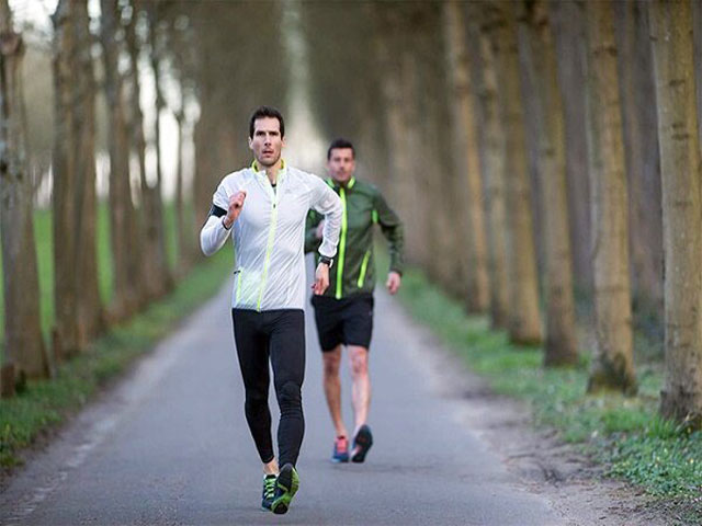 پیاده روی صحیح دو مرد با لباس ورزشی مناسب در جاده ای زیبا